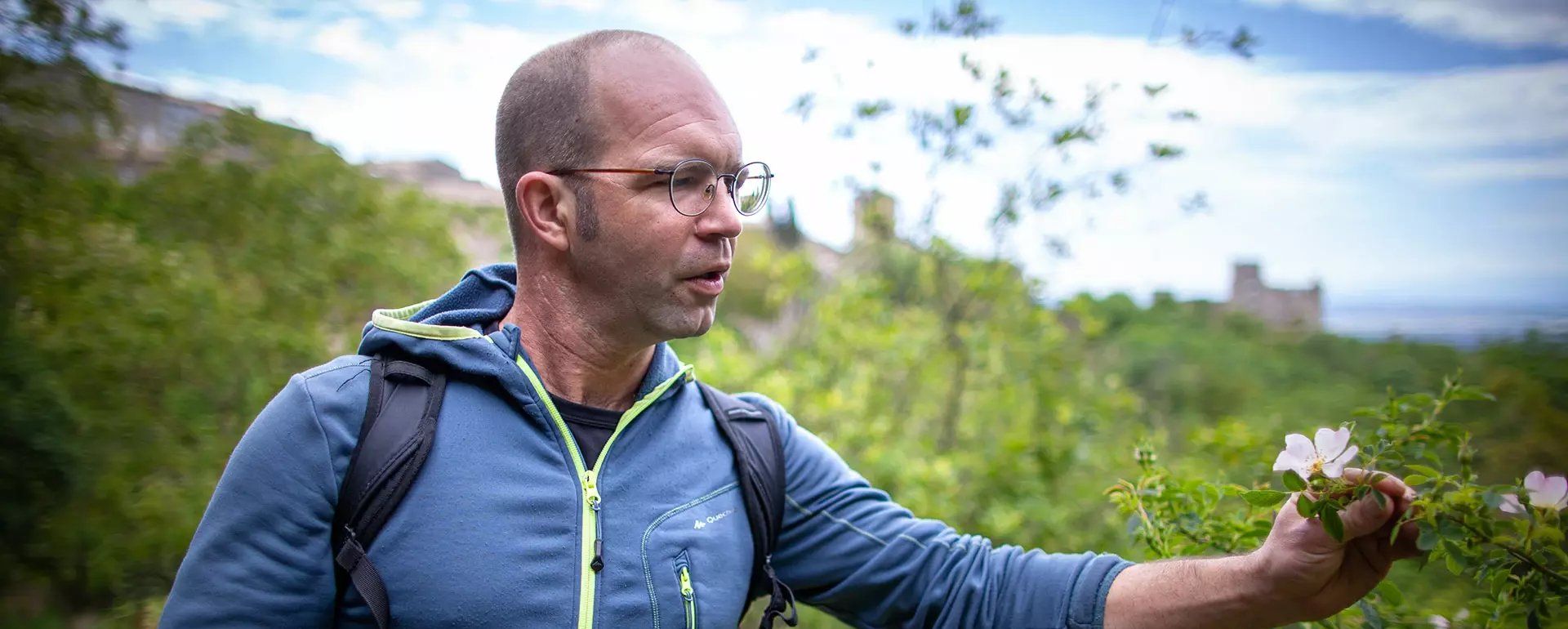 Nicolas Dreux, accompagnateur en montagne, montre une fleur sauvage en randonnée
